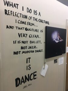 Wall text reading: "What I do is a reflection of the culture I come from... and that culture is very clear. It is not ballet, not jazz, not modern dance. It is dance. Joel Hall." 