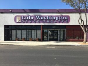 A white storefront with a purple sign reading "Lula Washington Dance Theatre"