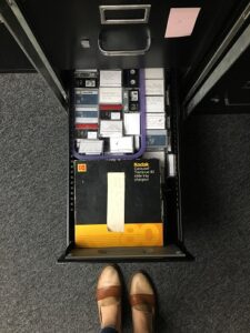 A drawer of a file cabinet open to show archival video tapes