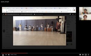 A screenshot of two women watching a video of Brazilian drummers