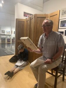 A man sitting in a chair looks at a photograph