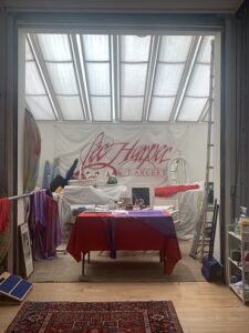 A table covered with red and purple cloths, under a glass roof