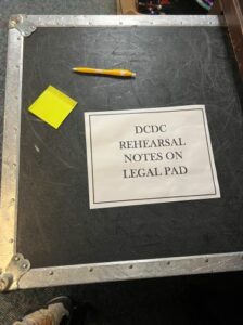 A trunk with a label reading "DCDC Rehearsal Notes on Legal Pads"