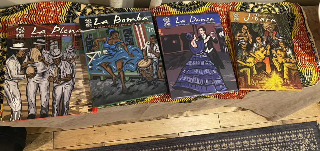 A series of journals with colorful covers depicting music and dance