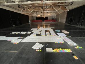 A large room with large sheets of white paper and and small colorful sticky notes all around