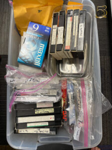 VHS tapes and DVDs in a large plastic bin
