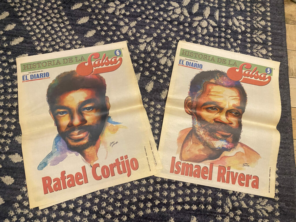 Two newspapers with colorful portraits of men on the front reading "Rafael Cortijo" and "Ismael Rivera"