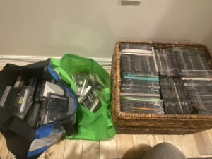 2 bags and 2 bins filled with tapes and discs