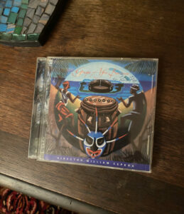 A CD case with a colorful cover depicting two people dancing and a large drum