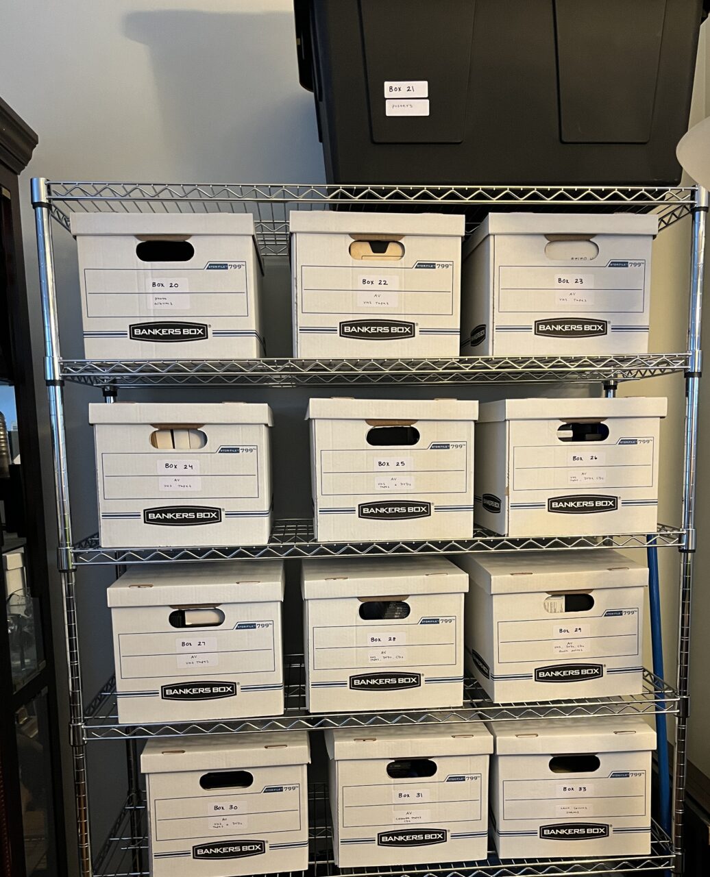 A shelf with four rows of three boxes each on it